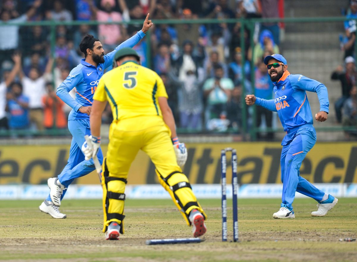 India's bowler Ravindra Jadeja (L) celebrates after he dismisded Australia's cricketer Aaron Finch during the fifth one-day international (ODI)cricket match between India and Australia at the Feroz Shah Kotla Stadium in New Delhi on March 13, 2019. (Photo by Sajjad HUSSAIN / AFP) / ----IMAGE RESTRICTED TO EDITORIAL USE - STRICTLY NO COMMERCIAL USE-----
